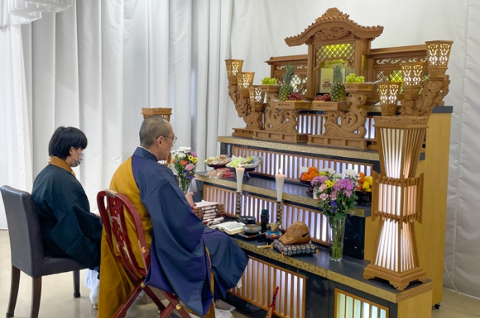 写真：祭壇の前でお坊さんがお経を読んでいます