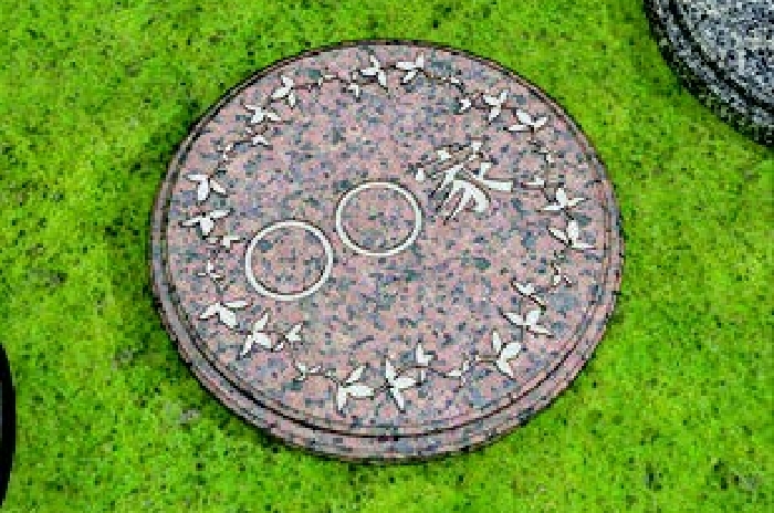 イラスト:赤・青・黒の石を組み合わせた納骨壇に、「〇〇家」と彫刻が入っています